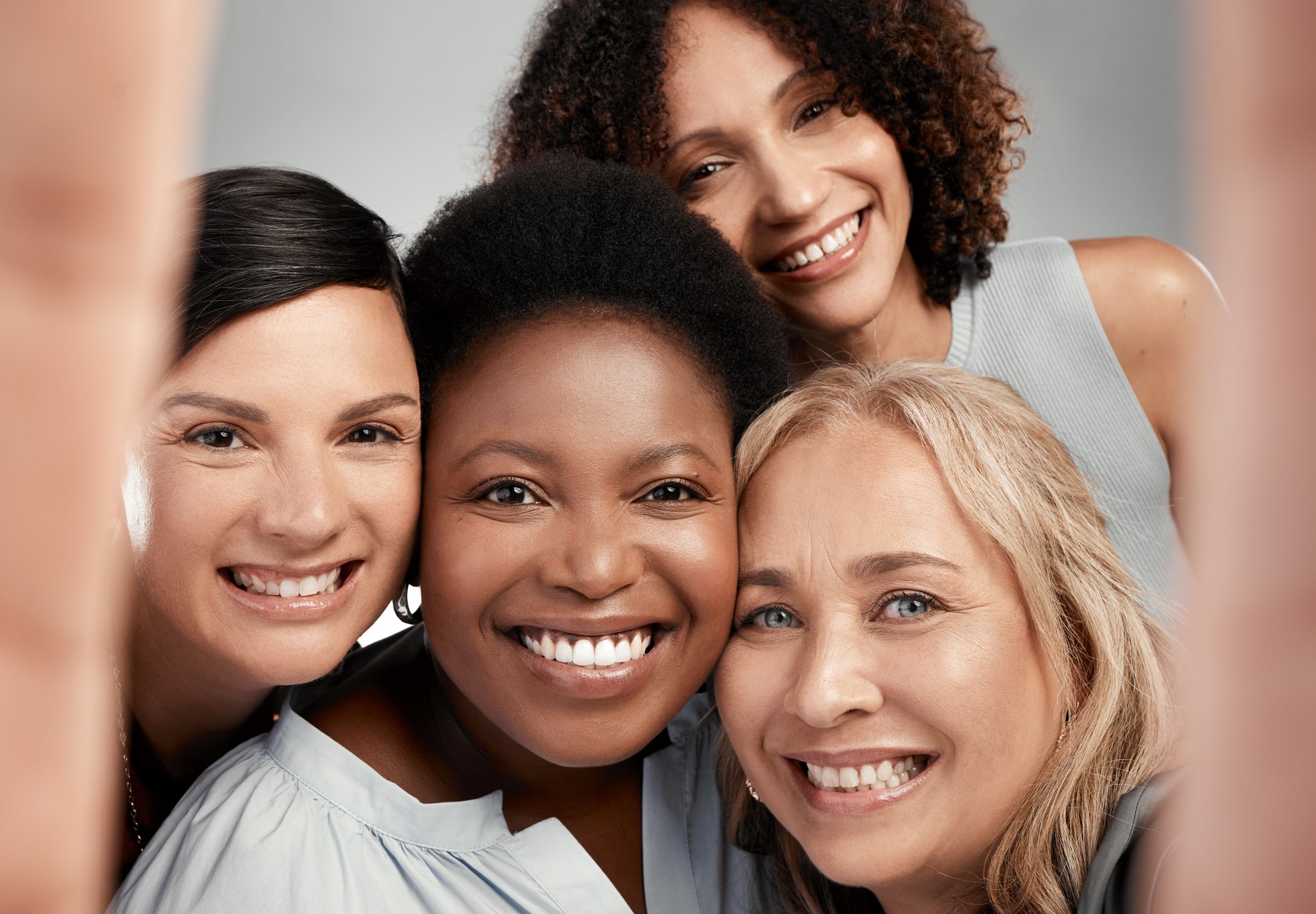 Shot of a diverse group of women standing close together in the studio and take a selfie